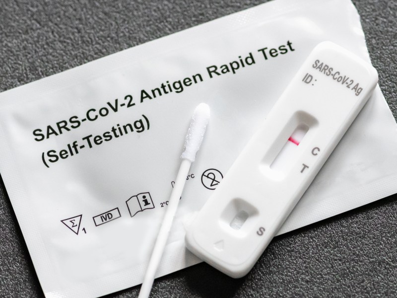 COVID test with swab, packaging and test results.