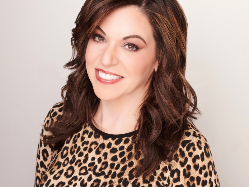 Sara Goodman Confino a woman with dark hair wearing leopard print, smiles