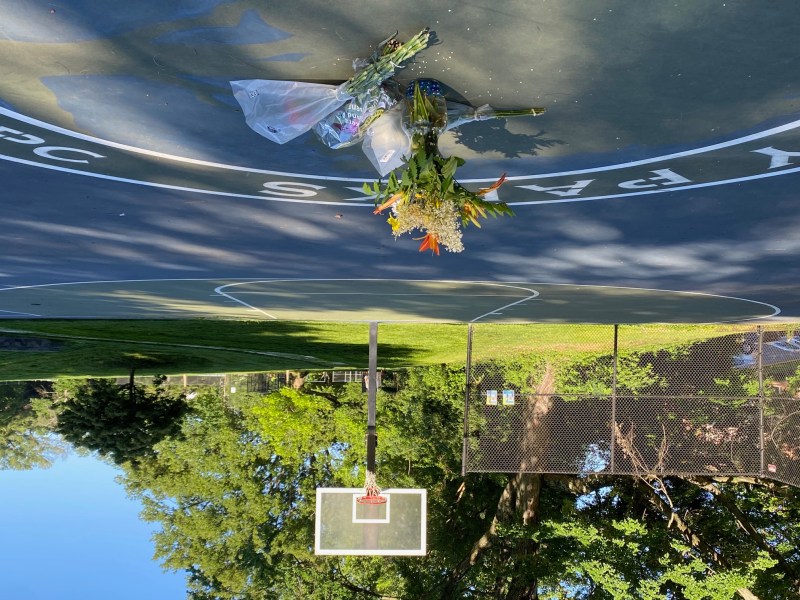 A vase and bouquets of flowers on a basketball court