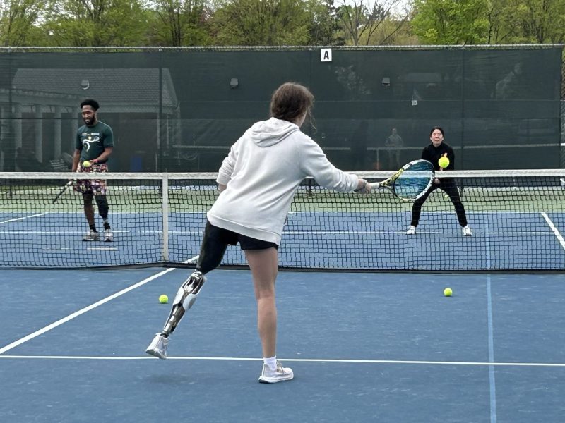 Athletes, some with prosthetic legs, on a tennis court