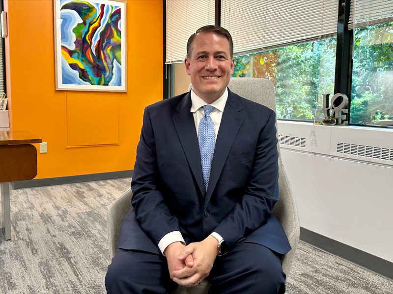 a man in a suit and tie smiles for a picture