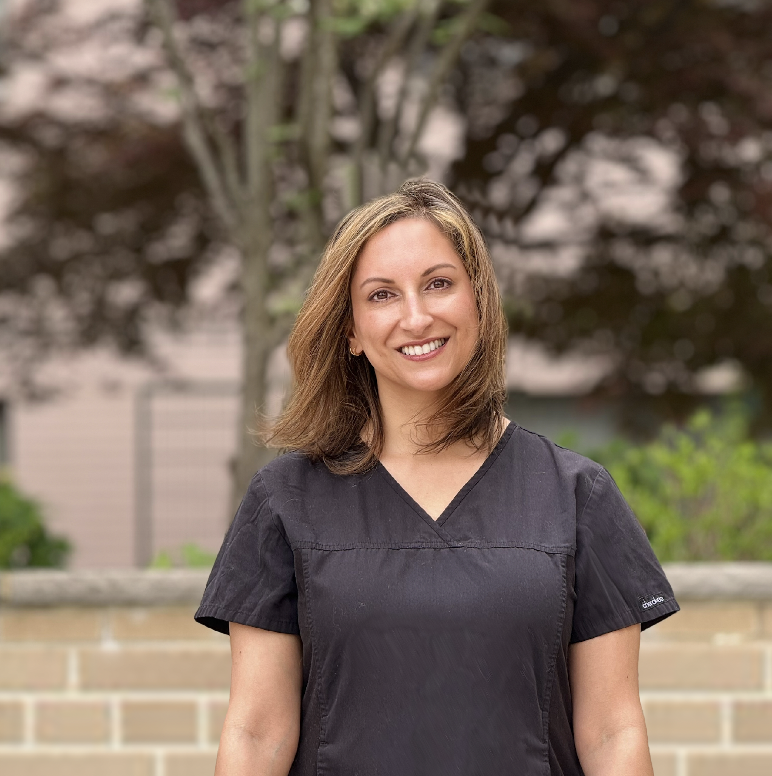 a smiling woman in scrubs